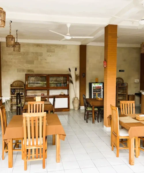 Open-air breakfast and reception area with wooden tables